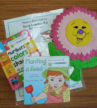 Early literacy kit about spring, with two books and a smiling pink flower puppet