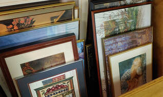 Large bin of stacked framed art 